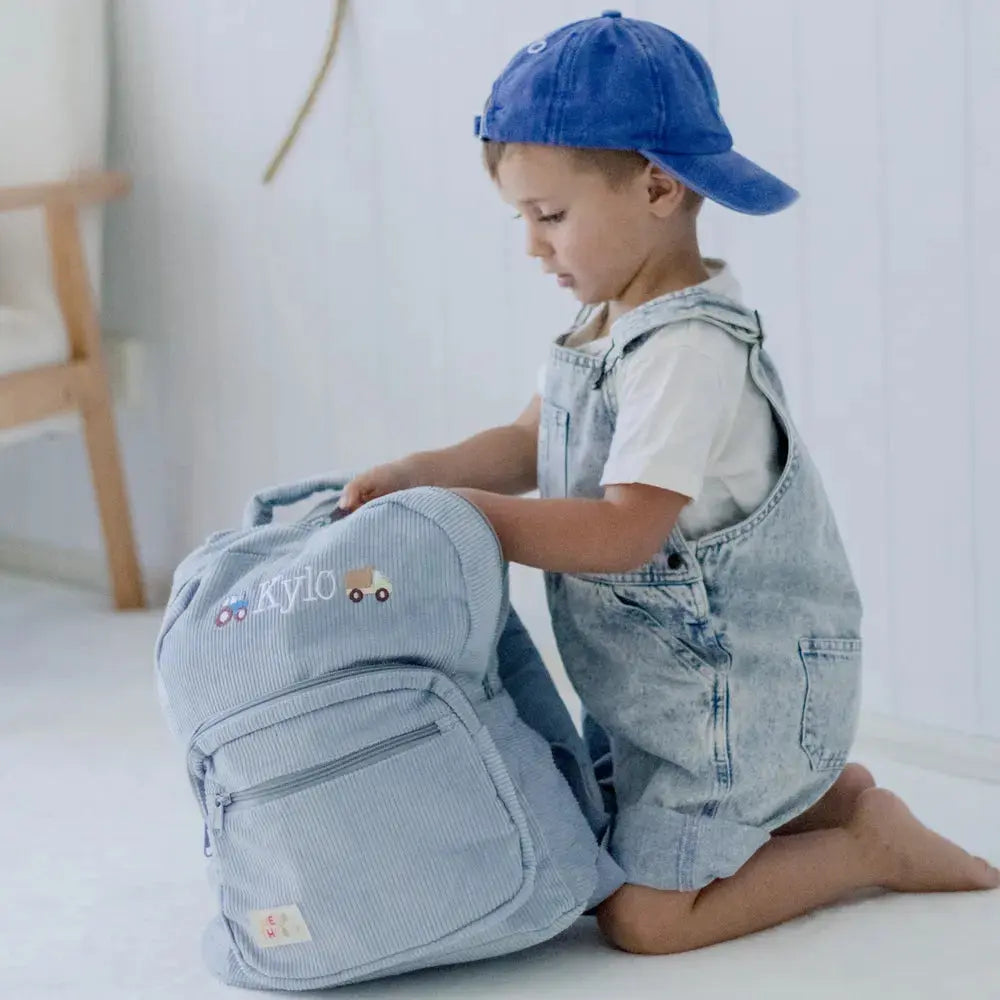 Personalised toddler backpack in corduroy – blue color. Child wearing custom name daycare backpack
