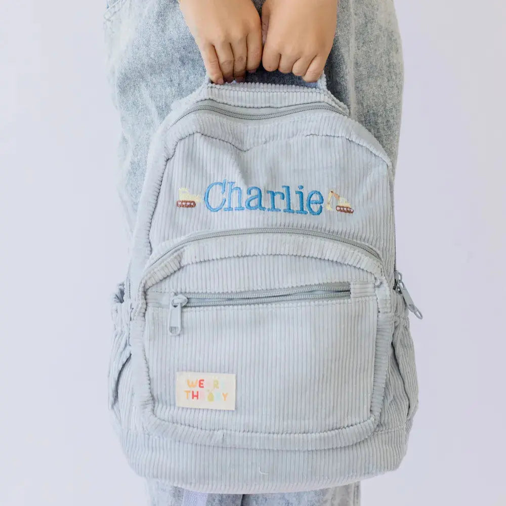Personalised toddler backpack in corduroy – blue color. Child wearing custom name daycare backpack
