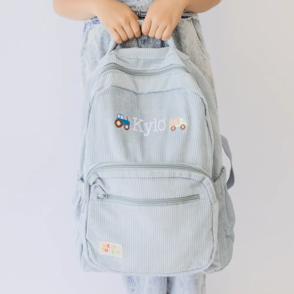 Personalised toddler backpack in corduroy – blue color. Child wearing custom name daycare backpack