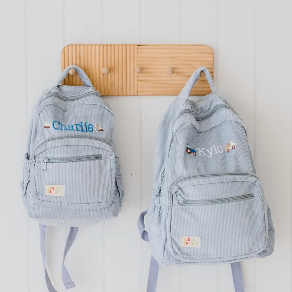 Personalised toddler backpack in corduroy – blue color. Child wearing custom name daycare backpack