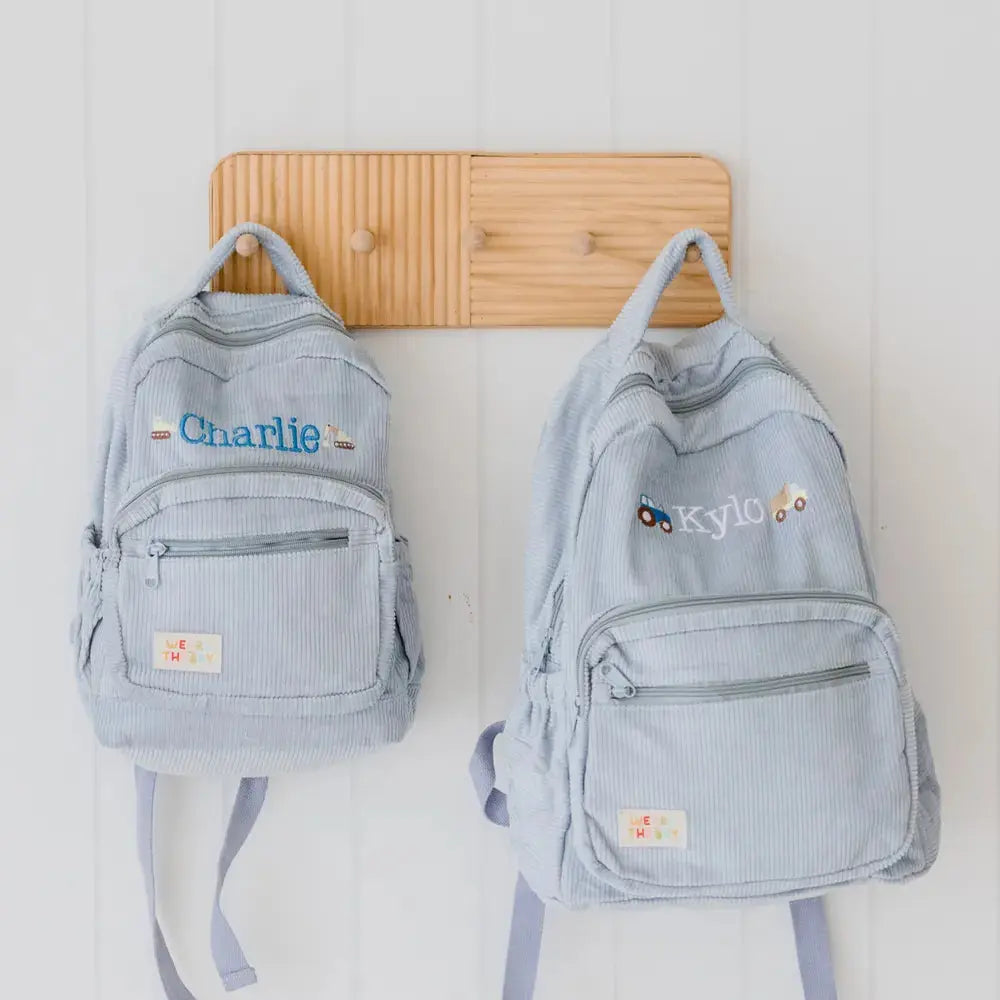 Personalised toddler backpack in corduroy – blue color. Child wearing custom name daycare backpack