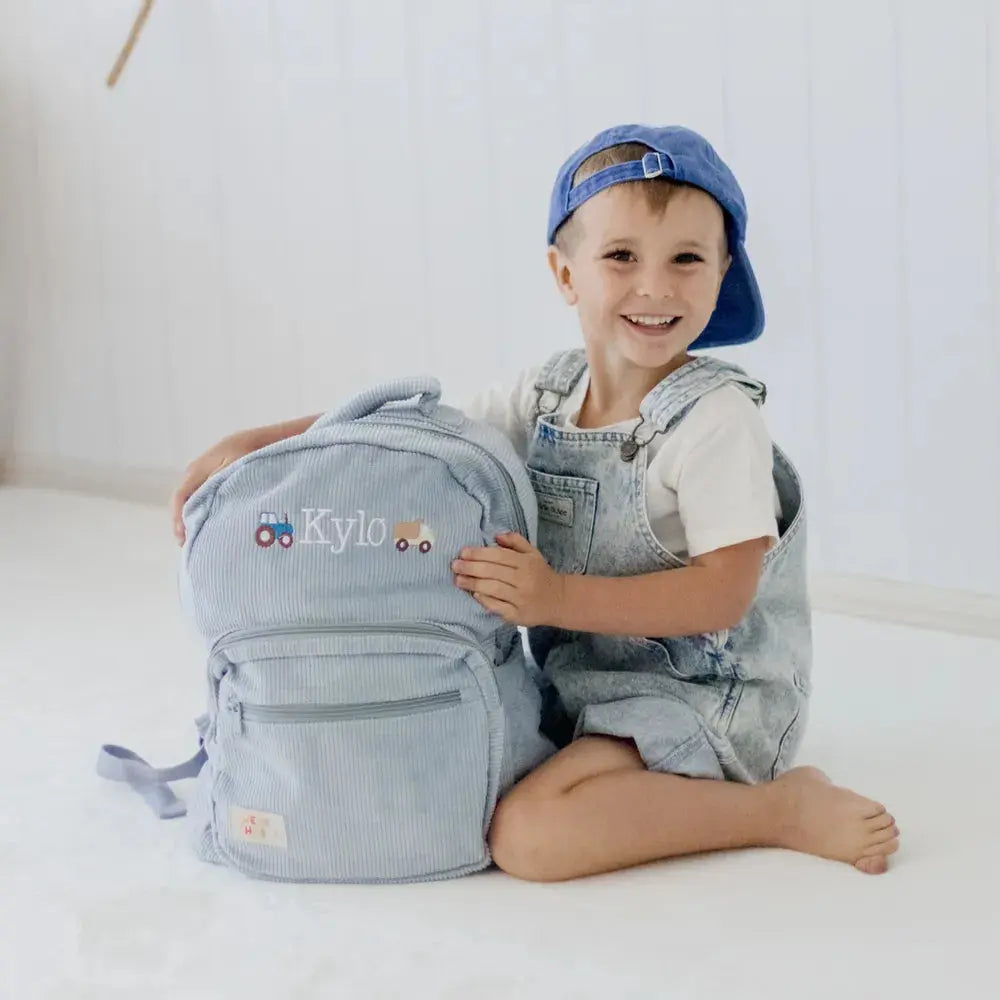 Personalised toddler backpack in corduroy – blue color. Child wearing custom name daycare backpack