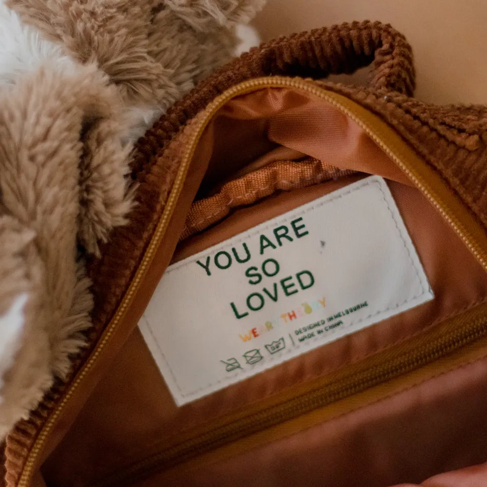 Personalised toddler backpack in corduroy – brown color. Child wearing custom name daycare backpack