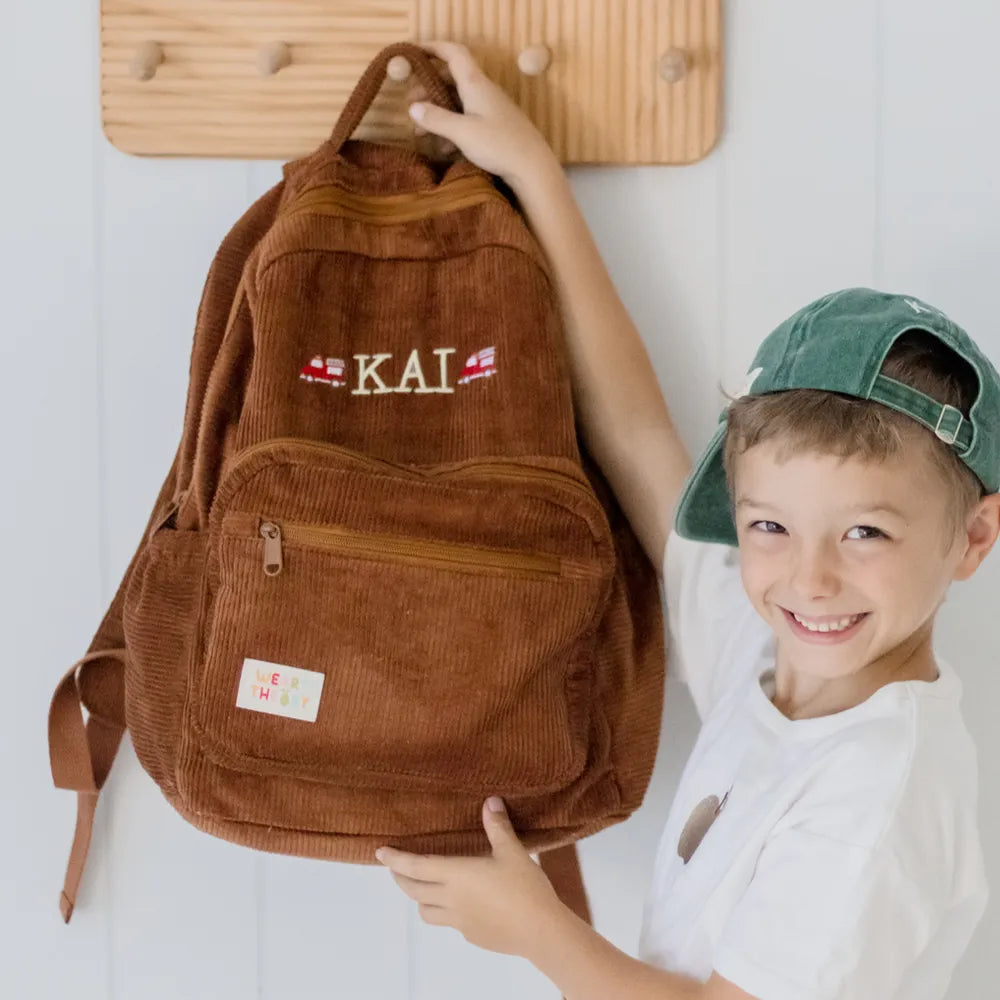 Personalised toddler backpack in corduroy – brown color. Child wearing custom name daycare backpack