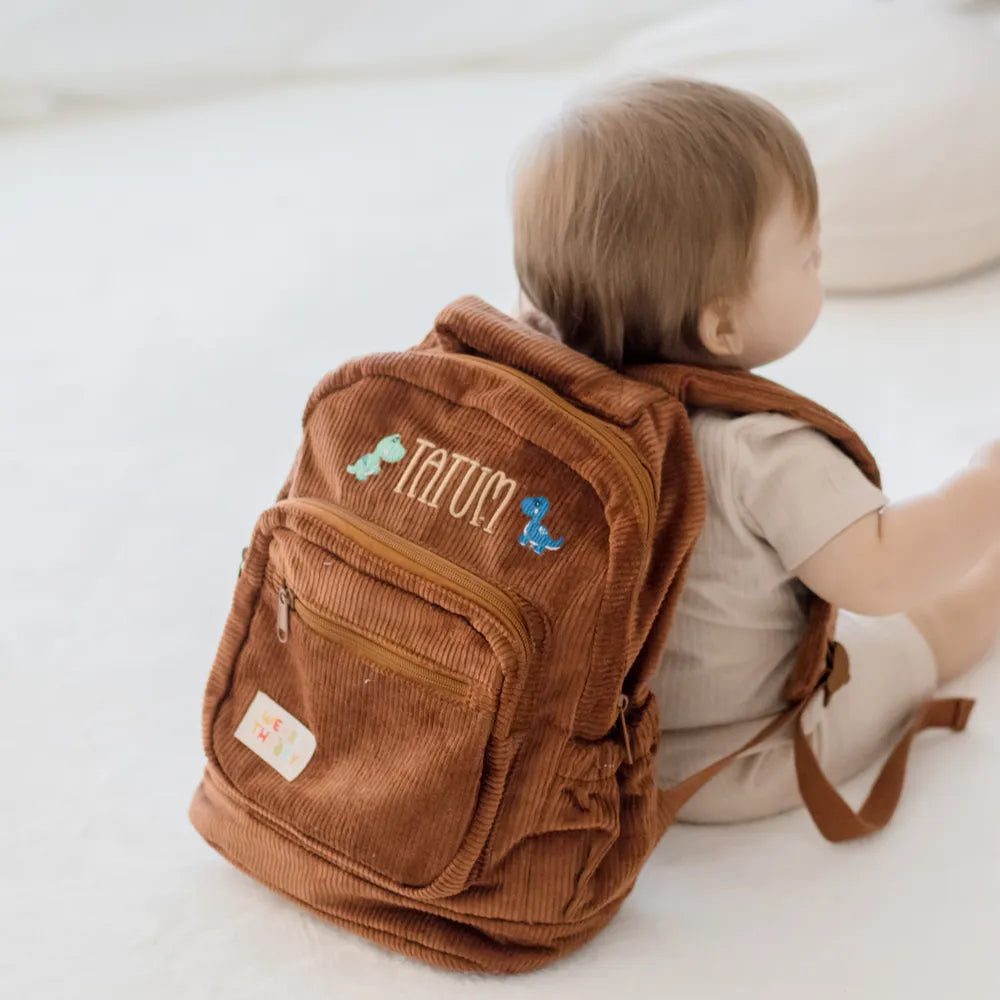 Personalised toddler backpack in corduroy – brown color. Child wearing custom name daycare backpack