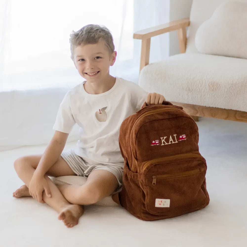 Personalised toddler backpack in corduroy – brown color. Child wearing custom name daycare backpack