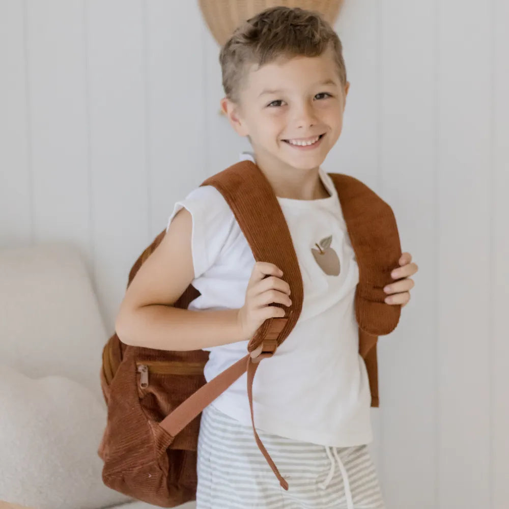 Personalised toddler backpack in corduroy – brown color. Child wearing custom name daycare backpack