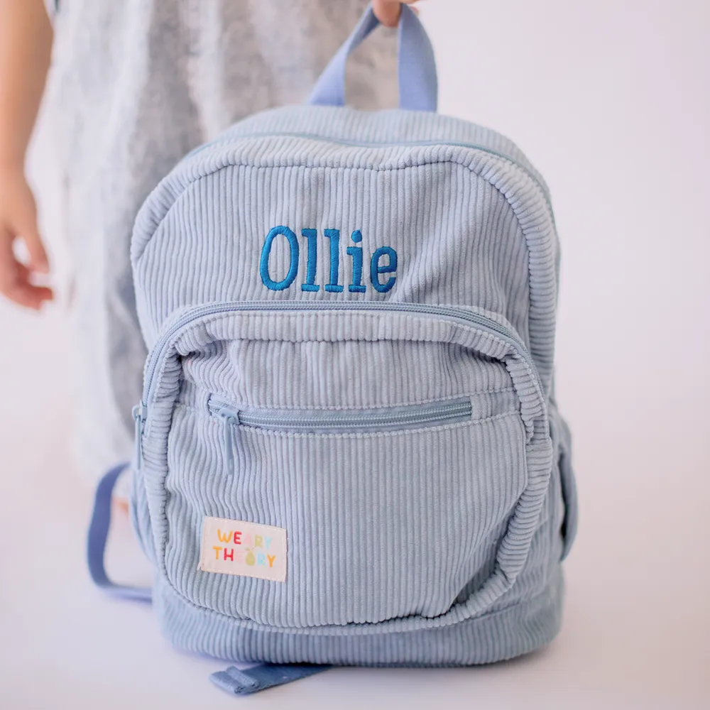 Child holding the Blueberry Corduroy Backpack