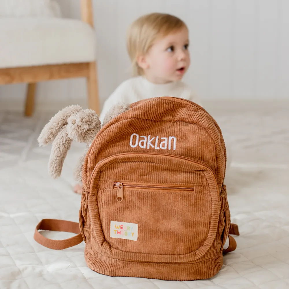 Chocolate Corduroy Backpack with child in the background