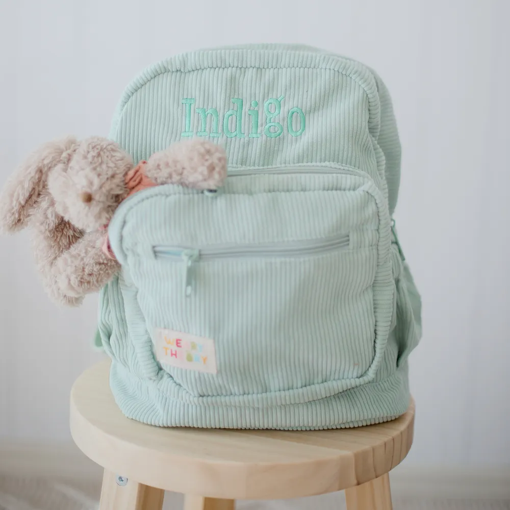 Pear Corduroy Backpack on a stool