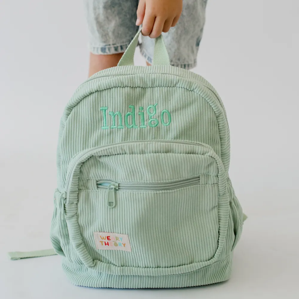 Child holding the Pear Corduroy Backpack