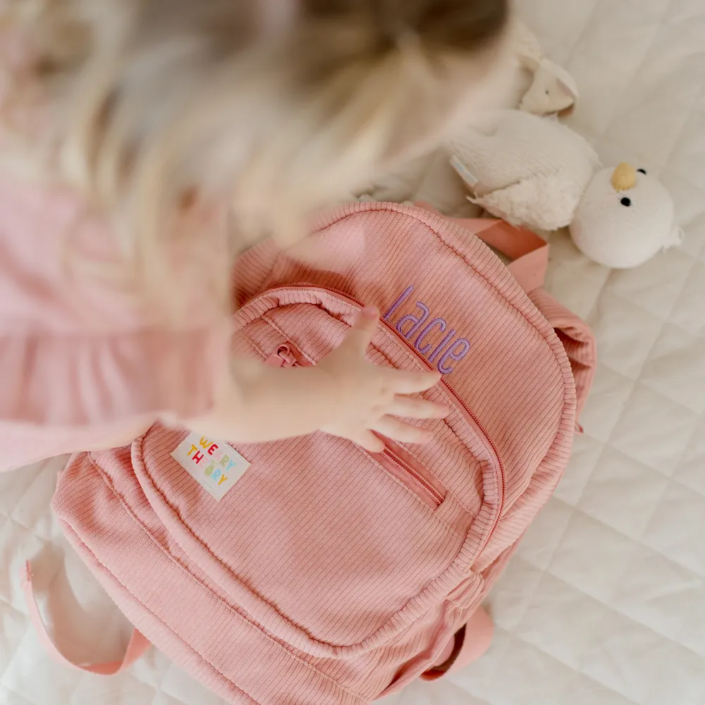 Child reaching for the Strawberry Corduroy Backpack