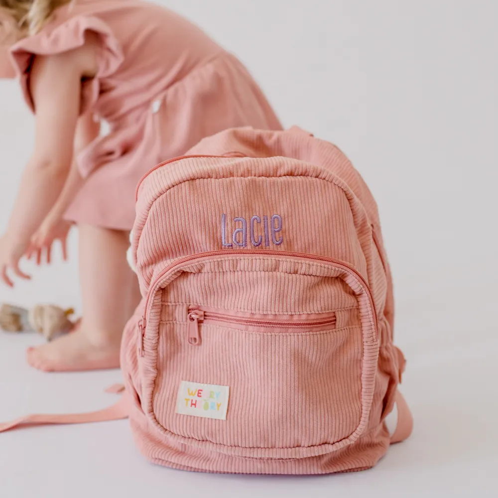 Strawberry Corduroy Backpack with child in the background