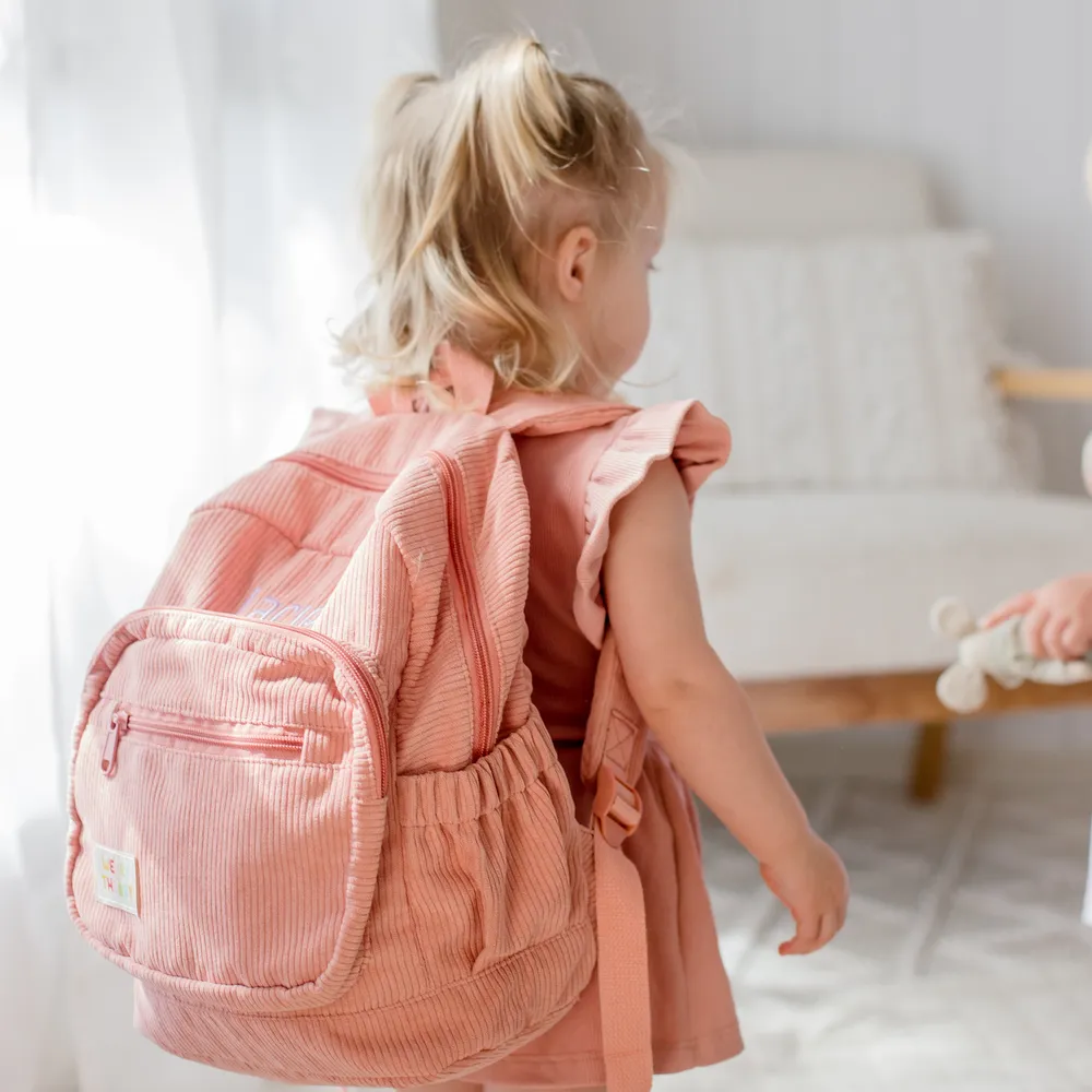 Child wearing the Strawberry Corduroy Backpack