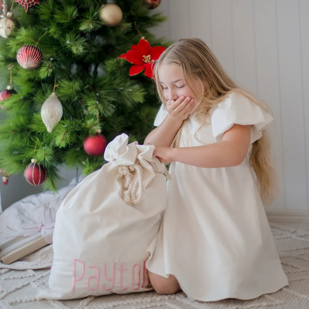 White Santa sack with embroidered name and somebody opening it